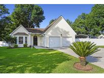 Charming single-Gathering home featuring an attached two-car garage, well-maintained lawn, and a mature palm tree at 103 Case Ct, Ladson, SC 29456