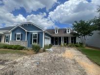 Charming blue home featuring a welcoming front porch, dormer windows, and landscaped yard with beautiful blue sky at 118 Magnolia House Dr, Summerville, SC 29486