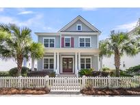 Charming two-story home with a white picket fence and tropical landscaping at 1392 Founders Way, Mount Pleasant, SC 29464