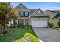 Charming two-story home featuring a manicured lawn, two-car garage, and inviting front porch at 2017 Asher Loop, Summerville, SC 29485