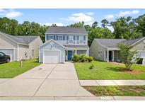 Charming two-story home with blue accents, a one-car garage, and a well-manicured front lawn at 251 Coosawatchie St, Summerville, SC 29485