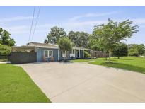 Charming blue home boasts a well-manicured lawn and a large concrete driveway and inviting curb appeal at 2605 Mona Ave, Charleston, SC 29414