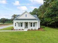 Charming single-story home featuring a welcoming front porch and a well-manicured lawn at 2872 Edenborough Rd, Johns Island, SC 29455