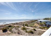 Beautiful beach view with sand dunes, ocean, and single Gathering home near the coast at 3004 Point St, Edisto Island, SC 29438