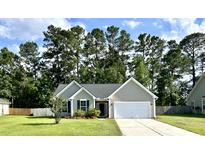 Charming single-Gathering home with a well-maintained lawn, a two-car garage, and mature trees in the background at 3006 Central Ring Ct, Ridgeville, SC 29472