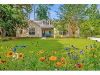 Charming single-story home boasting a beautifully landscaped yard with vibrant flowers at 5023 Manor Rd, Hollywood, SC 29449