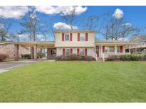 Two story home with brick and siding, green lawn, red shutters, and mature landscaping at 7659 Allwood Ave, North Charleston, SC 29418