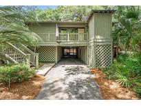 Inviting exterior view of a raised home with a covered carport and charming wood lattice at 1025 Scaup Ct, Kiawah Island, SC 29455