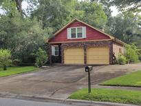 Charming two-story brick home featuring an attached two-car garage and a neatly manicured lawn with mature trees at 116 Sumners Aly, Summerville, SC 29485