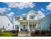 Charming two-story home with a welcoming front porch, landscaped yard, and great curb appeal under a bright sky at 1801 Sandybrook Dr, Mount Pleasant, SC 29466