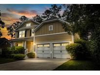 Charming two-story home with a two-car garage and professionally landscaped front yard at sunset at 188 Donning Dr, Summerville, SC 29483