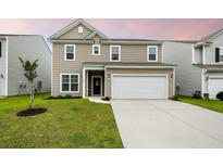 Charming two-story home featuring a two-car garage, a welcoming front door, and a well-manicured lawn at 209 Hayworth Rd, Summerville, SC 29486