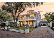 Charming two-story home with dual balconies, brick driveway, mature landscaping, and a convenient carport at 2142 Golfview Dr, Charleston, SC 29412