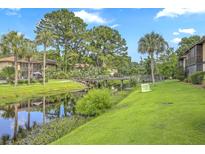 Scenic view of the community featuring a waterway, bridge, lush landscaping, and neighboring condo buildings at 2174 Bees Ferry Rd # G, Charleston, SC 29414