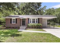Charming red brick home featuring a well-manicured lawn, traditional design, and convenient carport at 2631 Ridgewood Ave, Charleston, SC 29414