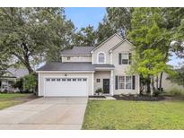 Charming two-story home featuring a well-manicured lawn, a two-car garage, and classic curb appeal at 2727 4 Winds Pl, Mount Pleasant, SC 29466