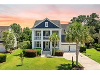 Charming two-story home with a well-manicured lawn, columns, and a two-car garage at 2981 Sturbridge Rd, Mount Pleasant, SC 29466