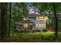 Charming two-story home with a covered front porch and well-maintained landscaping surrounded by mature trees at 427 Grape Arbor Drive Dr, Summerville, SC 29486