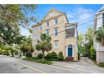 Beautiful multi-story tan home with lush landscaping and a striking blue front door at 65 Vanderhorst St # C, Charleston, SC 29403