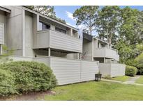 A charming two-story home with a fenced yard, mature trees, and gray wood plank siding at 103 Greencastle Dr, Goose Creek, SC 29445