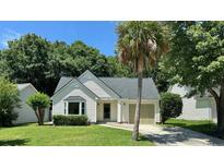 Charming single story home with manicured lawn, driveway, and a mature palm tree at 108 Alston Cir, Goose Creek, SC 29445