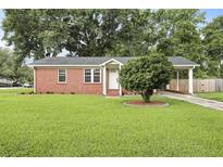 Charming brick home with manicured lawn, mature tree, and a convenient carport at 1105 Crull Dr, Charleston, SC 29407
