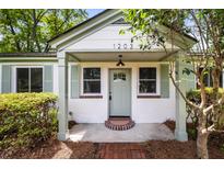 Charming home featuring a light green door, light green shutters, and brick accents at 1203 Forestwood Dr, Charleston, SC 29407