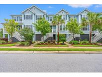 Charming light-blue townhouses with well-maintained landscaping and inviting staircases leading to the front doors at 1582 Prince Edward St, Mount Pleasant, SC 29466