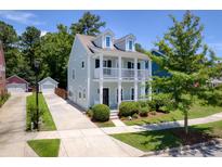 Charming two-story home with a double porch, lush landscaping, and a detached garage at 1666 Sparkleberry Ln, Johns Island, SC 29455