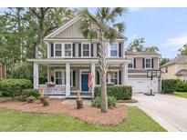 Charming two-story home with a welcoming front porch, beautiful landscaping, and an American flag at 1728 Wellstead St, Mount Pleasant, SC 29466