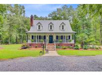Charming home featuring a metal roof, dormer windows, brick foundation, and a welcoming front porch at 196 Dogwood Ridge Rd, Summerville, SC 29485