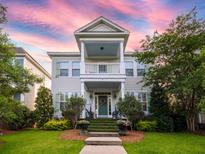 Charming two-story home featuring a welcoming porch, lush landscaping, and a vibrant green door at 206 White Gables Dr, Summerville, SC 29483