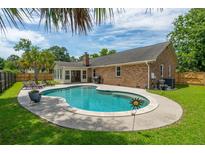 Inviting backyard oasis featuring a sparkling pool, lush greenery, and an outdoor living space at 2942 Foxhall Rd, Charleston, SC 29414