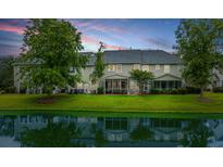 A serene backyard view featuring a lush lawn and pond, screened in porches, perfect for relaxation and outdoor living at 3012 Candela Grove Dr, Charleston, SC 29414