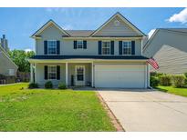 Charming two-story home featuring a manicured lawn, gray siding, black shutters, and a two car garage at 311 Aberdeen Cir, Summerville, SC 29483