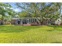 Expansive backyard features a well-maintained lawn, a deck and mature shade trees at 689 Port Cir, Charleston, SC 29412