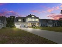 Charming two-story home boasts a two-car garage, long driveway, and inviting front porch at 7035 Pumpkinseed Dr, Johns Island, SC 29455