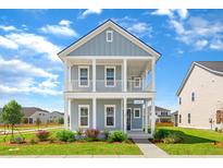 Charming two-story home with blue siding, white trim, a front porch, and a well-manicured lawn at 770 Clay Field Trl, Summerville, SC 29485