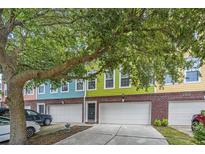 Charming colorful townhomes with brick accents and garages are shaded by a mature tree at 9305 Sweetbay Ct, Ladson, SC 29456