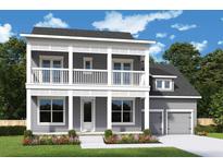 Charming two-story home with a welcoming front porch and balcony, complemented by a well-manicured lawn and a two-car garage at 1175 Reserve Ln, Awendaw, SC 29429