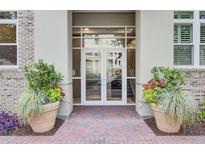 Inviting entrance to a residential building with double glass doors and attractive planters at 125 Pier View St # 209, Charleston, SC 29492