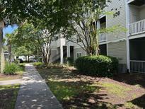 Inviting condo building with lush landscaping, sidewalks, and stairs leading to upper-level units at 1300 Park West Blvd # 519, Mount Pleasant, SC 29466