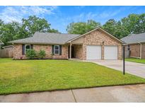 Charming brick home featuring a well-manicured lawn and a two-car garage at 1304 Pinyon Pine Dr, Ladson, SC 29456