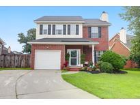 Charming two-story brick home featuring a well-manicured lawn and a white garage door at 1328 Lark Ln, Hanahan, SC 29410