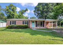 Charming brick home featuring a well-maintained lawn and a welcoming turquoise front door at 1520 Kirklees Abbey Dr, Charleston, SC 29407