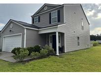Two-story home with gray siding, black shutters, green lawn, and a covered front porch with white pillars at 167 Brittondale Rd, Summerville, SC 29485