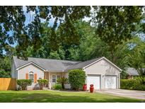 Charming single-Gathering home with a well-manicured lawn, a two-car garage, and mature trees at 1975 Fruitwood Ave, Charleston, SC 29414