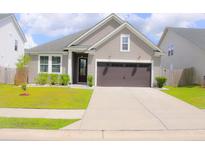 Charming single Gathering home with a two-car garage, well-manicured lawn and neutral color scheme at 303 Citation Way, Moncks Corner, SC 29461