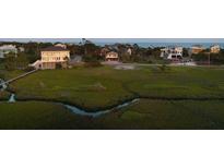 Expansive marshfront lot featuring a home near the beach with a dock at 31 W 9Th St, Folly Beach, SC 29439