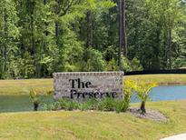 Brick community sign for The Preserve with lush landscaping near a pond and many trees at 3902 Summerton St, Mount Pleasant, SC 29466